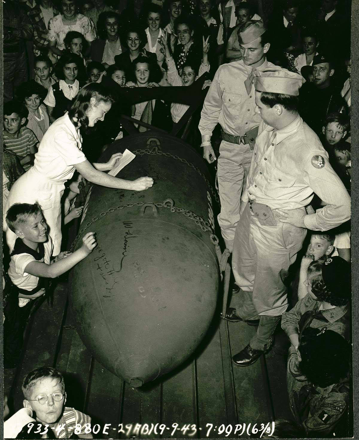 Children write messages on a blockbuster bomb, September 9, 1943. U.S. Army Air Corps, State Archives, Connecticut State Library. Used with permission.